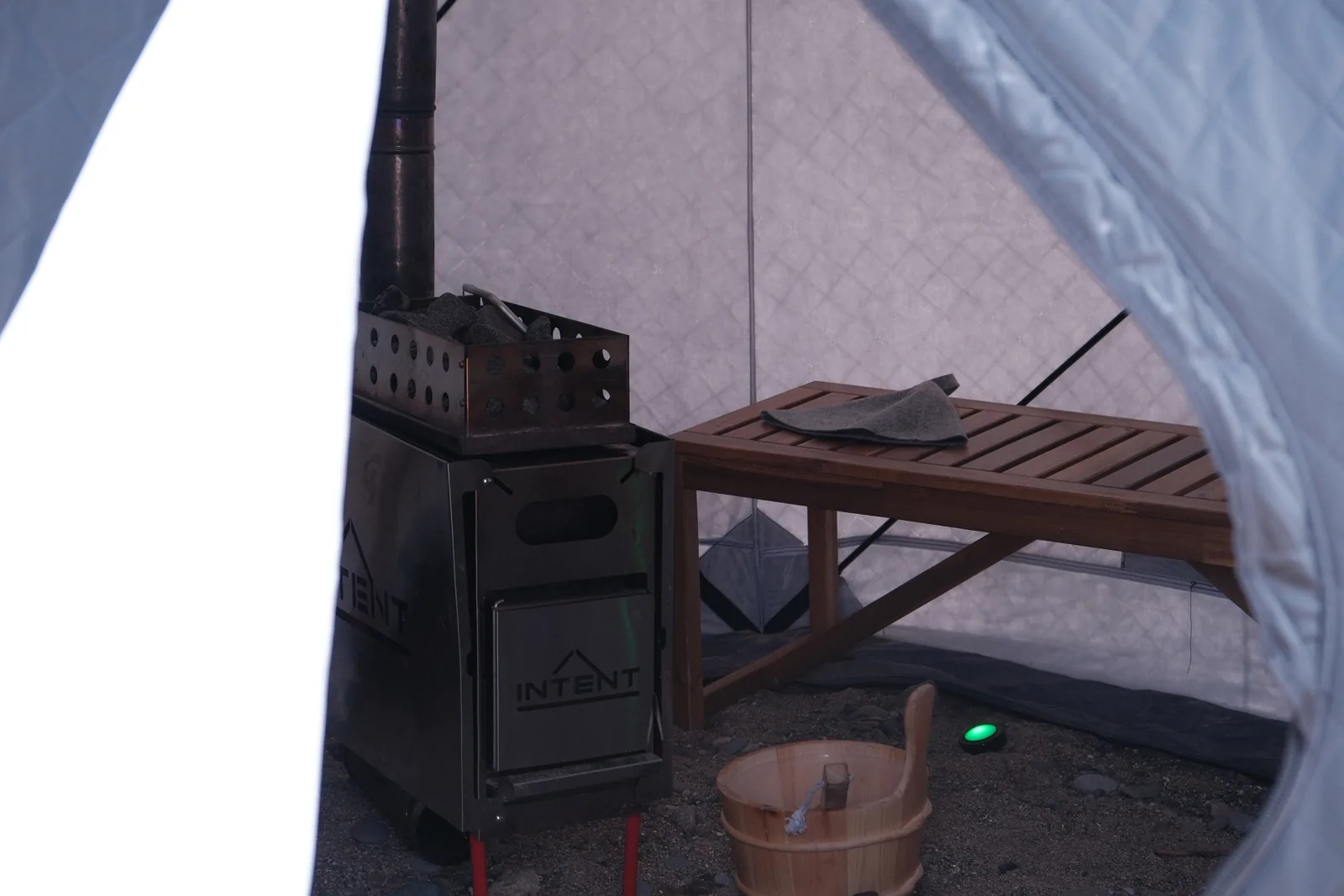 The wood-fired stove and wooden bench inside the beach sauna