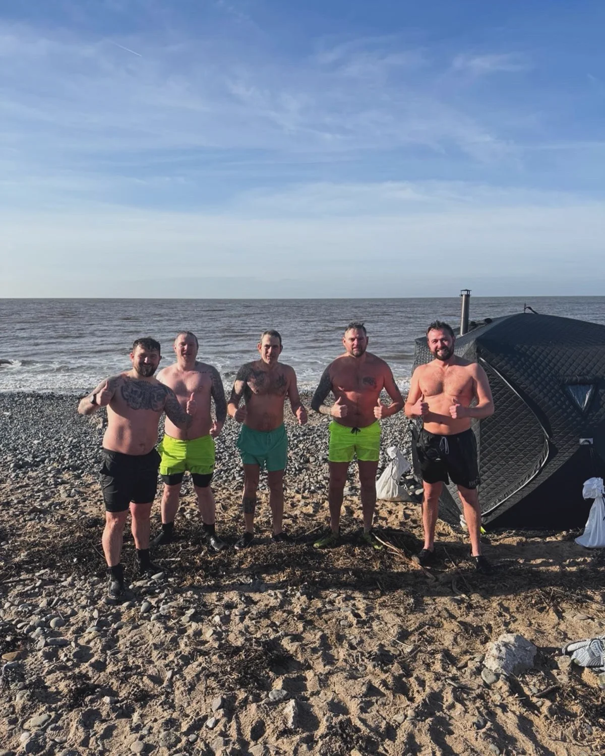 Brotherhood members beside the beach sauna after a session