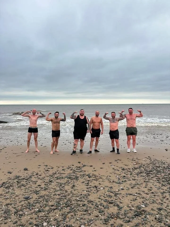 Six Brotherhood members on Rossall Beach at a past sauna and sea dip event