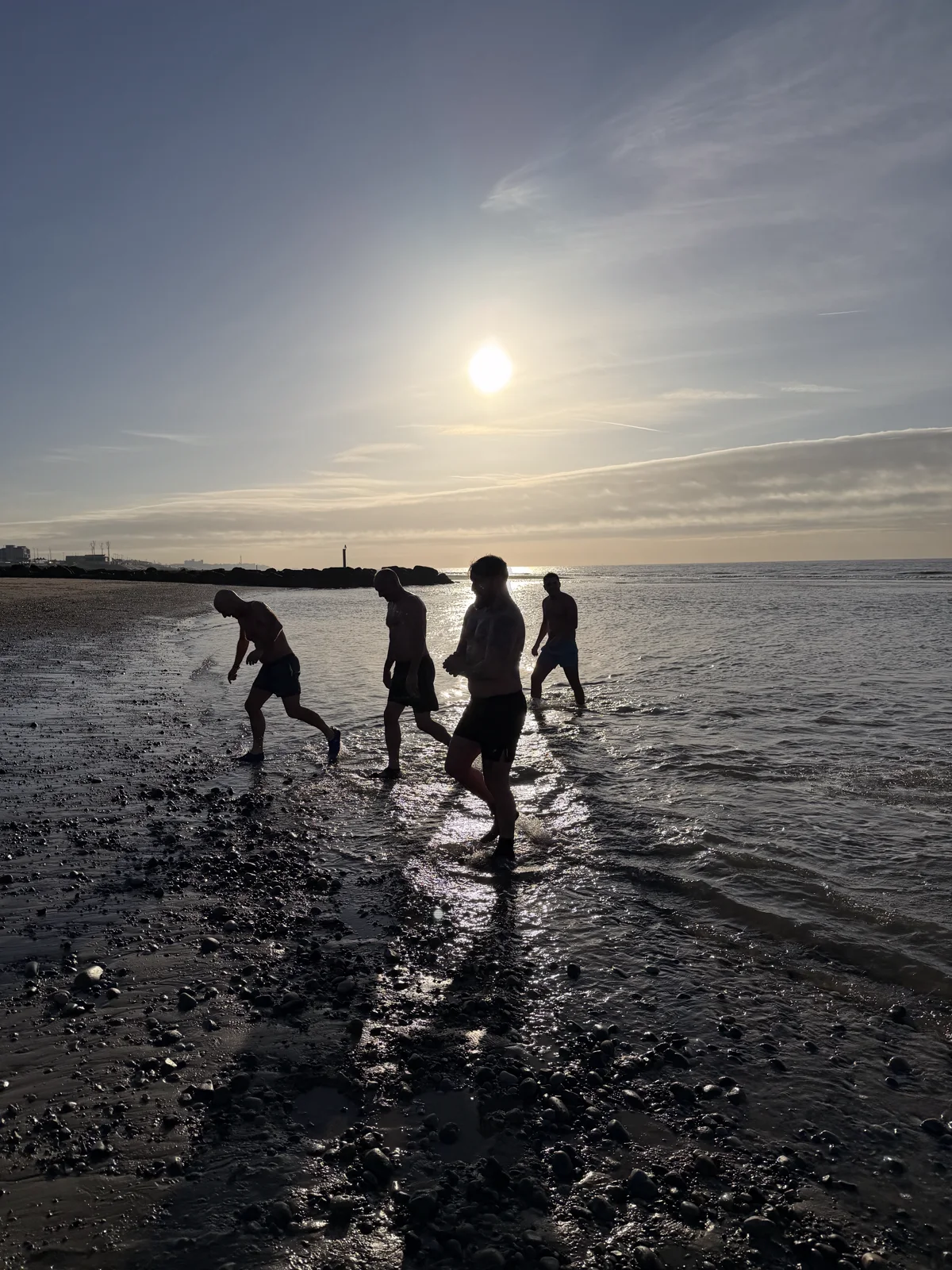 Men returning from a sea dip in the evening light